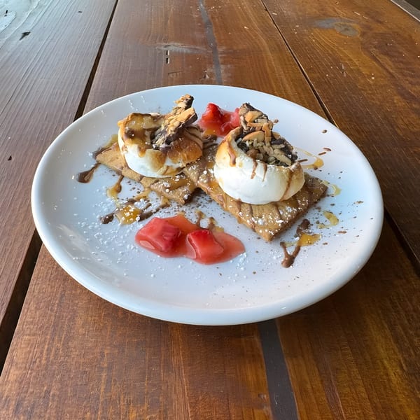 Cafe Enza's s'mores dessert with toasted marshmallows, chocolate, nuts, and strawberry compote.