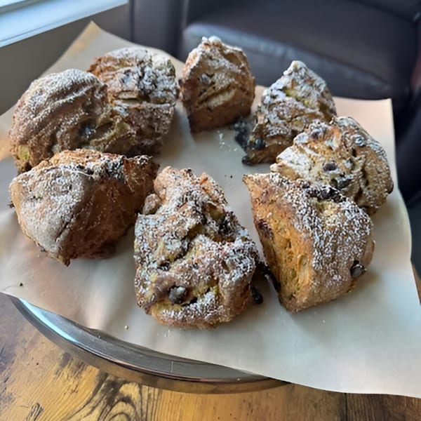 A platter of eight chocolate chip scones dusted with powdered sugar from Cafe Enza.